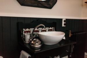 a bathroom with a bowl sink on a black counter at Hulbert House Luxury Boutique Lodge Queenstown in Queenstown