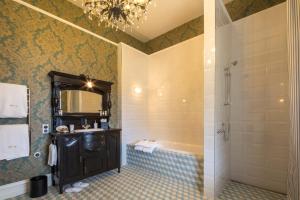 a bathroom with a shower and a sink and a mirror at Hulbert House Luxury Boutique Lodge Queenstown in Queenstown
