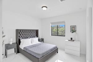 Habitación blanca con cama y ventana en Renzzi Wynwood Apartments, en Miami