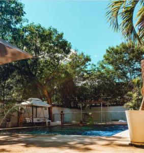 a patio area with a pool and a beach umbrella at Hotel Infinito La Casona in Villavieja