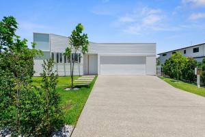 a modern house with a driveway at The Luxury White House in Peregian Springs