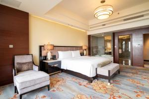 1 dormitorio con cama, escritorio y silla en InterContinental Heilong Lake, an IHG Hotel, en Meishan