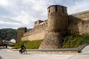 a person riding a bike in front of a castle at Hostal Monteclaro in Ponferrada