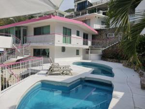 a house with a swimming pool and a building at CASA DE DESCANSO VILLA DIAMANTE in Acapulco