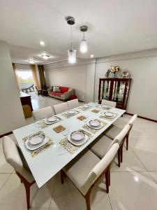 a dining room with a white table and chairs at 3 SUITES Vista Mar - WI-FI, PISCINA, SAUNA, ACADEMIA, GARAGEM 2 CARROS in Ilhéus
