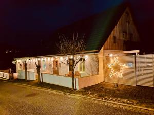 une maison avec des lumières de Noël sur son côté dans l'établissement Pension Zum grünen Kakadu, à Göhren