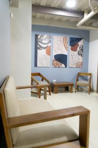 Habitación con 2 sillas y pinturas en la pared. en M1145 Aparta Loft, en Pereira