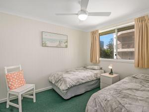 um quarto com 2 camas, uma cadeira e uma janela em Como Unit 6 em Gold Coast
