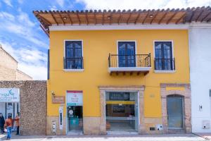 - un bâtiment jaune avec des fenêtres et un balcon dans l'établissement Ayenda Bochica, à Tunja