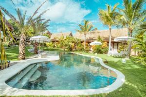 a swimming pool in a yard with palm trees at Mule Malu Tropical Stay in Uluwatu
