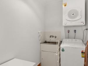 a small kitchen with a sink and a washing machine at Peninsula Waters Unit 14 Soldiers Point Road 2 in Soldiers Point