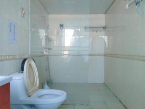 a white bathroom with a toilet and a shower at 都市小憩青旅 in Shenzhen