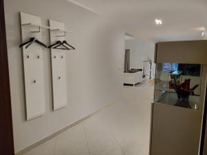 una cocina con paredes blancas y perchas en la pared en Modern 3 bedroom apartment near Useldange castle, en Useldange