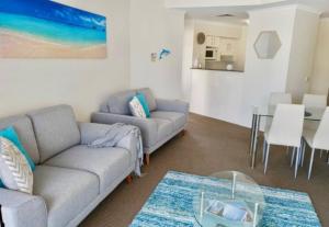 a living room with a couch and a table at 814 Shoal Bay Waterviews in Shoal Bay