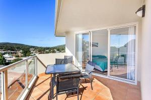 a balcony with a table and chairs and a bedroom at 814 Shoal Bay Waterviews in Shoal Bay