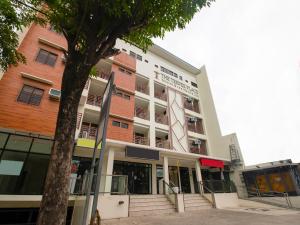 um edifício com uma árvore em frente em Super OYO 832 The Teepee Place Hostel & Residence Inn em Cebu