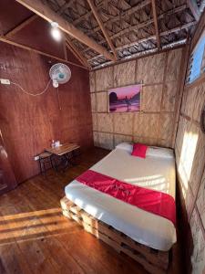 1 dormitorio con 1 cama en una habitación con mesa en RedDoorz Hostel Monaliza Surf Resort en San Juan