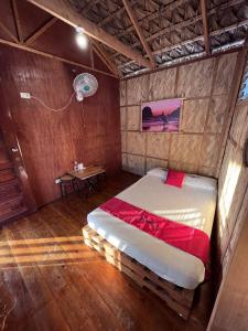 a bedroom with a bed in a room with a table at RedDoorz Hostel Monaliza Surf Resort in San Juan