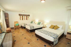 a hotel room with two beds and a chair at GUAJIRA CASA DEL MAR in Ríohacha