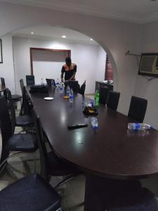 a man sitting at a large table in a room at Room in Lodge - Prince Of Anthony 1960 Hotel-apartment in Lagos