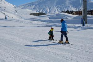 a man and a child on skis in the snow at 2-room Apartment NFT Gudauri Penta 701 in Gudauri