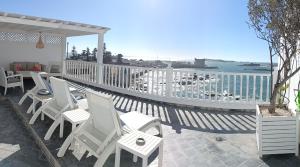 einen Balkon mit weißen Stühlen und Meerblick in der Unterkunft Jack's Apartments & Suites in Essaouira