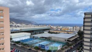 ein großes Gebäude mit einem Pool vor einer Stadt in der Unterkunft DREAM 4YOU in Santa Cruz de Tenerife