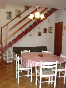 a dining room with a table and a staircase at Newly renovated villa with private garden in Porto Santa Margherita di Caorle