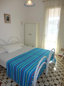 a bedroom with a bed with a striped blanket on it at Newly renovated villa with private garden in Porto Santa Margherita di Caorle