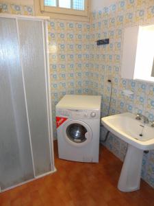 a bathroom with a washing machine and a sink at Newly renovated villa with private garden in Porto Santa Margherita di Caorle