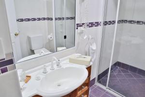 a bathroom with a white sink and a shower at Central Park Motel in Rockhampton