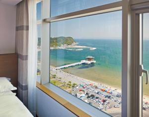 a view of a beach from a hotel room window at Lahan Hotel Pohang in Pohang