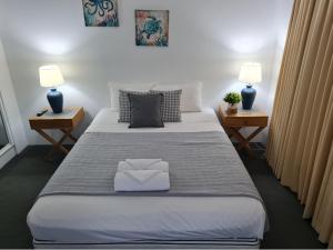 a hotel room with a bed and two lamps at Surfcomber on the Beach in Maroochydore
