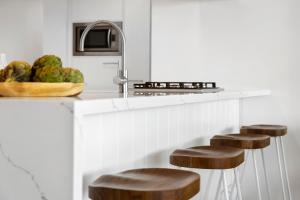 cocina con encimera con taburetes y fregadero en Designer Rooms at Q1 resort - GCLR, en Gold Coast