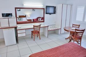 uma cozinha com uma secretária e uma mesa com cadeiras em Central Park Motel em Rockhampton