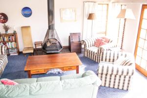a living room with couches and a fireplace at Graceland Farm in Underberg