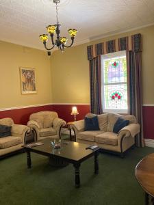 a living room with couches and a table and a window at Avon Terrace Guest House in York