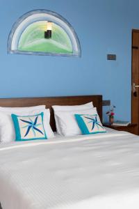 Cool Mount Resort في إيلا: سرير مع وسائد بيضاء و زرقاء في غرفة النوم