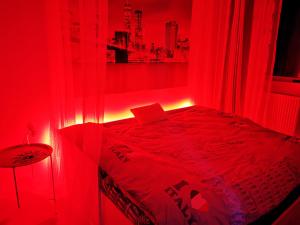 - une chambre rouge avec un lit avec une lumière rouge dans l'établissement Iași Jacuzzi Apartment H, à Iaşi