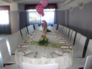 een lange tafel met witte stoelen en roze ballonnen bij Hotel Parco in Castellammare di Stabia