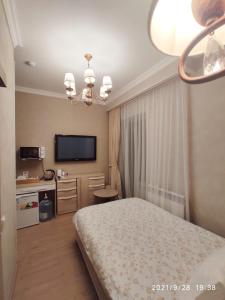 a bedroom with a bed and a television in it at Altyn in Astana