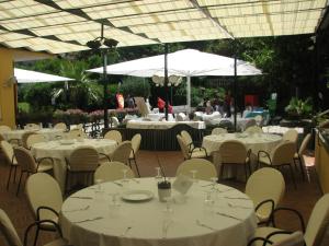 a group of tables and chairs with white tables and white umbrellas at Hotel Parco in Castellammare di Stabia