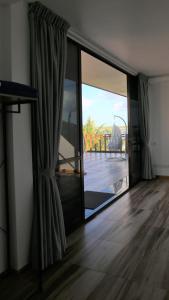 a room with a sliding glass door with a view of a deck at Kudhi Boli Beach House in Thulusdhoo