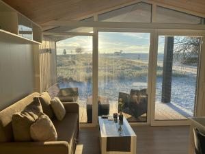 ein Wohnzimmer mit einem Sofa und einem großen Fenster in der Unterkunft Modernes Tiny House -neu 2021- in Uigendorf