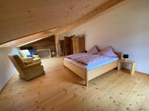 um quarto com uma cama e uma cadeira num sótão em Ferienhaus Pottmeyer em Kollnburg