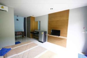 a living room with a room with a television at Phumi Resort in Thalang