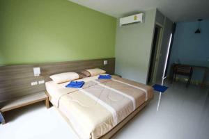 a bedroom with a large bed in a room at Phumi Resort in Thalang