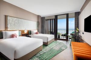 um quarto de hotel com duas camas e uma televisão em Hotel Indigo Suzhou Yangcheng Lake, an IHG Hotel em Suzhou
