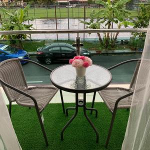 a table with a vase of flowers on a balcony at SBS HOTEL in Padang Besar