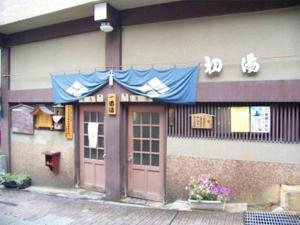 een gebouw met een deur en een bord erop bij Hatsunoyu in Yamanouchi
